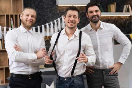 Electrolysis is for men, too! 3 men standing, smiling at cameral, wearing dressing white shirts. The one in the centre is wearing suspenders that hes pulled forward with his thumbs,