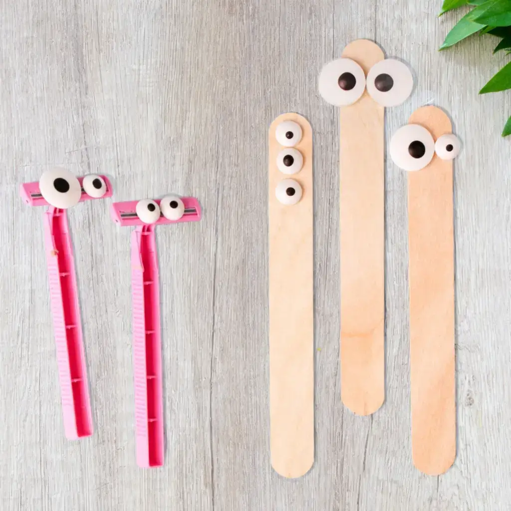 3 wooden waxing popsicle sticks with googly eyes looking straight on at the camera and 2 disposable pink razors with googly eyes, looking over at the popsicle sticks.